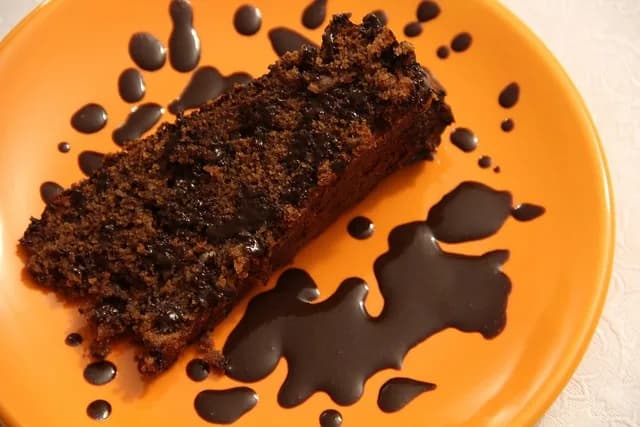 Fatia de bolo caseiro de castanhas e chocolate num prato, pronto a servir em família.
