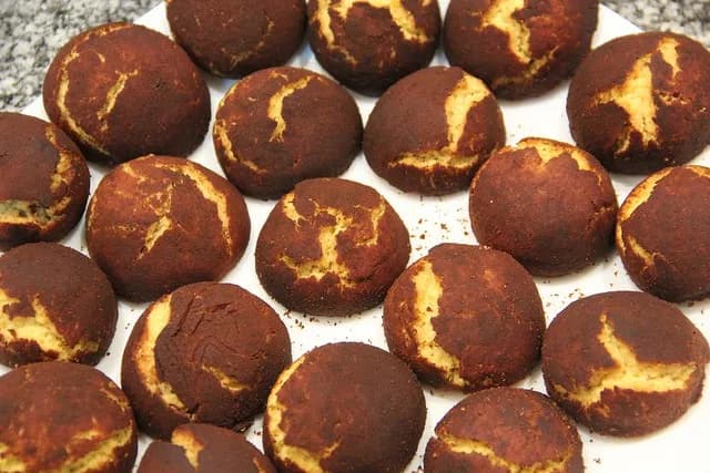 Prato com vários biscoitos de manteiga polvilhados com canela sobre uma mesa.