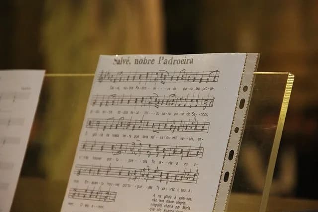 Pauta musical aberta com notas sobre o banco de uma igreja de estilo clássico.