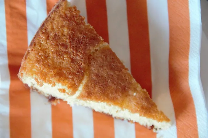 Bolo de São Jorge caseiro acabado de cozer e apresentado numa travessa decorada sobre uma mesa.