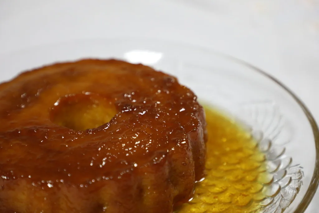 Pudim de abacaxi caseiro servido com rodelas de fruta fresca num prato de sobremesa.