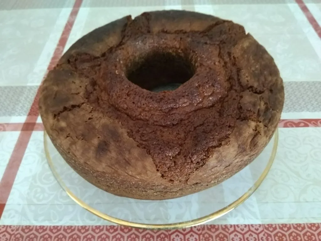 Bolo de chiffon fofinho de cacau servido num prato, acompanhado por uma bola de gelado de natas.