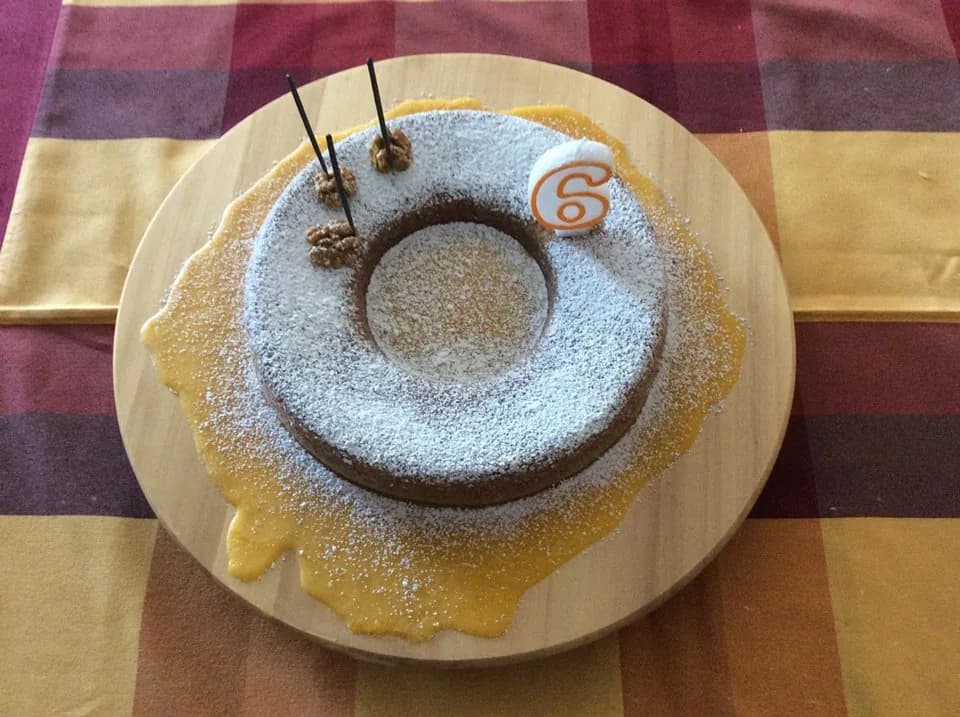 Um fofo bolo de anjo caseiro com cobertura dourada de ovos-moles servido num prato de sobremesa.